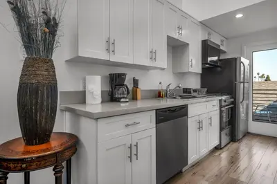 a kitchen with white cabinets and a vase at Koreatown Hollywood Urban Oasis 1 Bedroom Loft with Private Parking and Balcony in Los Angeles