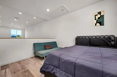 a bedroom with a bed and a couch and a window at Koreatown Hollywood Urban Oasis 1 Bedroom Loft with Private Parking and Balcony in Los Angeles