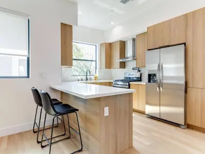 a kitchen with wooden cabinets and a stainless steel refrigerator at Modern Luxe Retreat Three-Bedroom #4 in Los Angeles