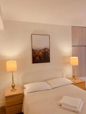 a bedroom with a white bed with two lamps at Western Romaine in Los Angeles