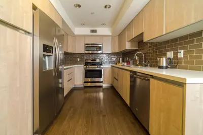 a large kitchen with wooden floors and stainless steel appliances at Western Romaine in Los Angeles