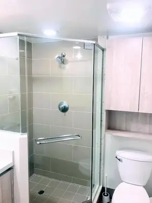 a bathroom with a glass shower with a toilet at Western Romaine in Los Angeles