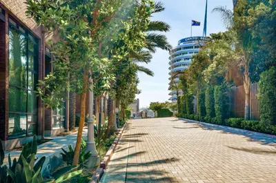 a cobblestone street with palm trees and a tall building at Loft & Luxe Hollywood with FREE PARKING in Los Angeles