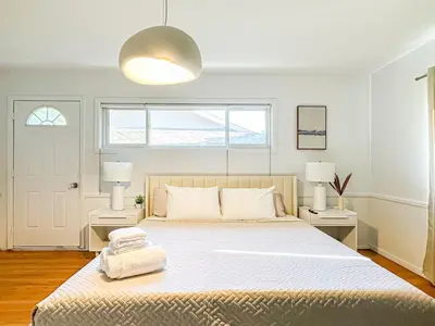 a white bedroom with a large bed with two lamps at 6BR Pool Escape for Friends and Family - LOU1 - BUR in Burbank