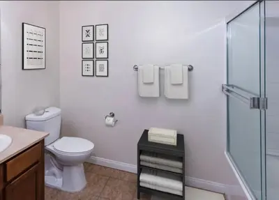 a bathroom with a toilet and a glass shower at LA Koreatown Nest House - Modern, Free Parking, Pool and Sauna, No Cleaning Fee in Los Angeles