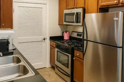 a kitchen with a stainless steel refrigerator and a microwave at LA Koreatown Nest House - Modern, Free Parking, Pool and Sauna, No Cleaning Fee in Los Angeles