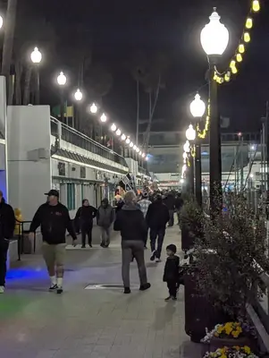 a group of people walking down a street at night at 31 night required rental Waterfront penthouse 180 ocean view in Redondo Beach