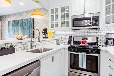 a white kitchen with a stove and a sink at Mickey's Corner in Anaheim