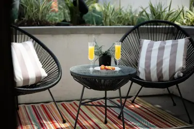 two chairs and a table with two glasses of orange juice at Tangerine Terrace -10 min to Disney&Angel Stadium in Orange