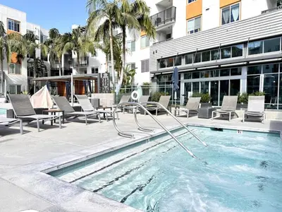 a swimming pool with chairs and a slide in front of a building at Tangerine Terrace -10 min to Disney&Angel Stadium in Orange
