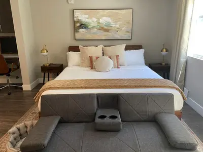 a bedroom with a large bed with a dog sitting on it at Tangerine Terrace -10 min to Disney&Angel Stadium in Orange