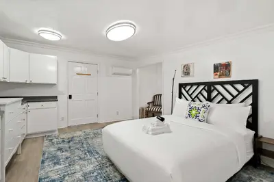 a white bedroom with a large bed and a kitchen at New Listing Burbank Bungalow by Colby&Conrad in Los Angeles