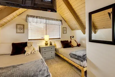 two twin beds in a room with a window at 2 Mi to Lake Arrowhead Pet-Friendly Cabin in Lake Arrowhead