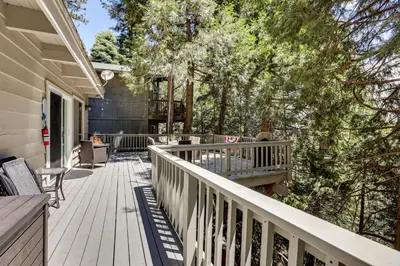 a deck with chairs and tables on a house at 2 Mi to Lake Arrowhead Pet-Friendly Cabin in Lake Arrowhead