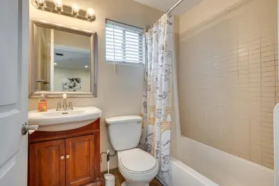 a bathroom with a toilet and a sink and a mirror at 4 Mi to Beverly Hills Quiet LA Gem with Shared Yard in Los Angeles