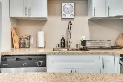 a kitchen counter with a sink and a clock on the wall at 4 Mi to Hollywood Mid-Wilshire Couples Retreat in Los Angeles