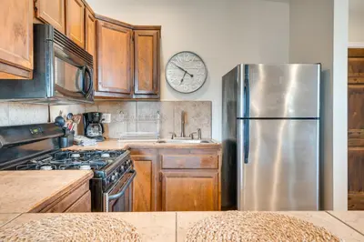 a kitchen with a stainless steel refrigerator and a clock on the wall at 9 Mi to Airport WFH-Friendly Apt in Los Angeles! in Los Angeles