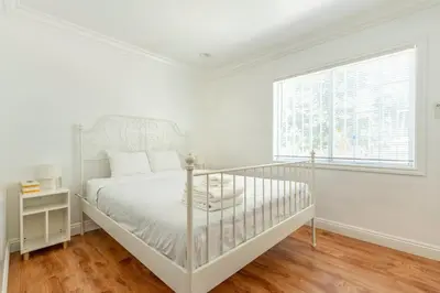 a white bedroom with a bed and a window at Ideal 4BR2BA Home for Family Vacations in Alhambra