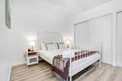 a white bedroom with a white bed with a white headboard at Cozy Guesthouse near Downtown Alhambra in Alhambra