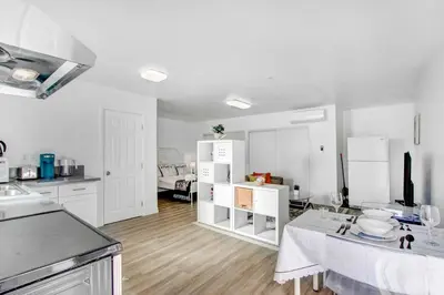 a kitchen with white cabinets and a table in a room at Cozy Guesthouse near Downtown Alhambra in Alhambra