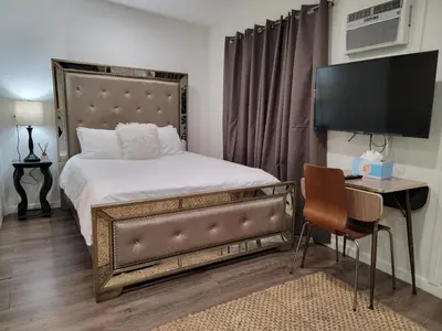 a bedroom with a bed and a desk with a television at Guest suite near La Cienega Park Beverly Hills next to LACMA La Brea Tar Pits Peterson Museum and Academy Awards Museum in Los Angeles