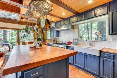 a kitchen with blue cabinets and a wooden ceiling at 3 Mi to Lake Arrowhead Village Dog-Friendly Cabin in Lake Arrowhead