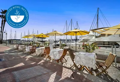a row of tables and chairs with yellow umbrellas at Marina Escape 2BR Townhouse with FREE PARKING in Los Angeles