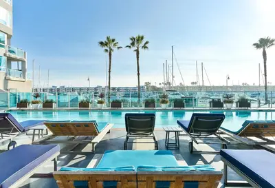 a large swimming pool with chairs and palm trees at Marina Escape 2BR Townhouse with FREE PARKING in Los Angeles