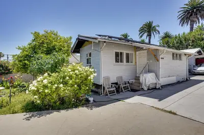 a white house with a table and chairs in a driveway at 3 Mi to Beaches Low-Key San Pedro Rental! in San Pedro