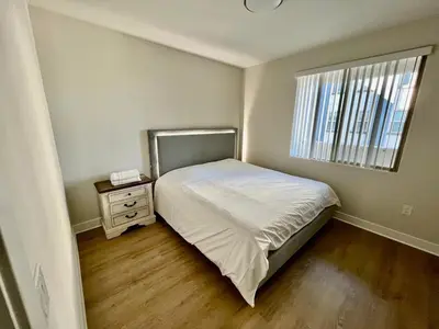 a small bedroom with a bed and a window at Miracle Mile Apartments in Los Angeles