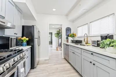 a kitchen with white cabinets and stainless steel appliances at Prime location King Bed! Private house1 in Alhambra