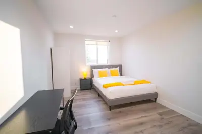 a bedroom with a bed and a desk and a window at The Command Suite Urban Comfort Near USC in Los Angeles