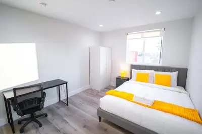 a bedroom with a bed and a desk and a television at The Command Suite Urban Comfort Near USC in Los Angeles