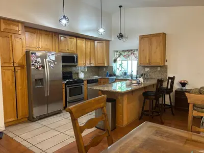 a kitchen with wooden cabinets and a stainless steel refrigerator at \u6e29\u99a8\u5c0f\u5c4b in Ontario