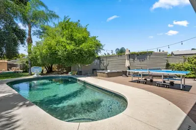 a swimming pool with a table and two ping pong tables at The Royer Retreat With Pool and Hot tub in Los Angeles