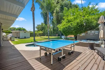 a ping pong table on a deck next to a pool at The Royer Retreat With Pool and Hot tub in Los Angeles