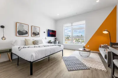 a bedroom with a large bed and a couch at Chic Studio, Walk to Downtown With Skyline Views in Los Angeles