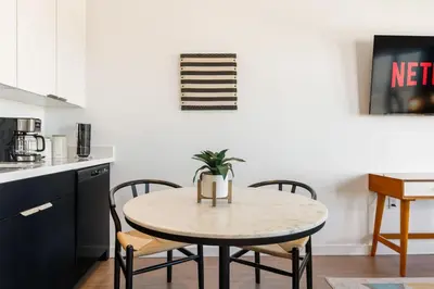 a kitchen with a table and chairs in a kitchen at Modern Studio Retreat in the Heart of Art District in Los Angeles