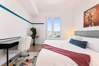 a bedroom with a bed and a desk and a window at Arts District Condo, Walk to Little Tokyo Plaza in Los Angeles
