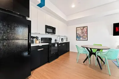 a kitchen with a table and a black refrigerator at Chic Studio with Stunning DTLA Views, Walk to Metro in Los Angeles