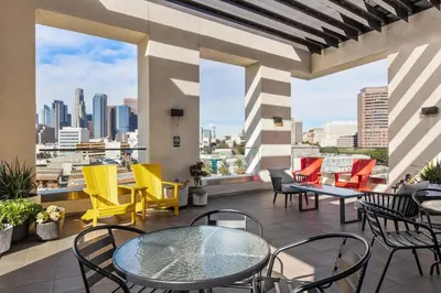 a patio with tables and chairs and a view of the city at Chic Studio with Stunning DTLA Views, Walk to Metro in Los Angeles