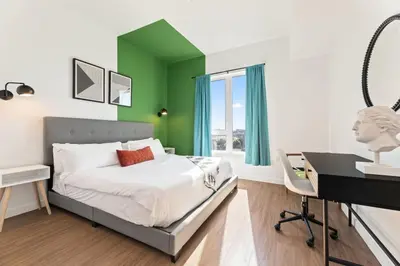 a bedroom with green walls and a bed with a desk at Unique 1-Bedroom DTLA Escape with City Views in Los Angeles