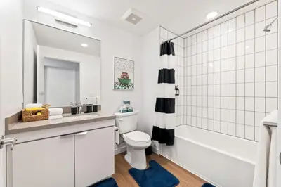 a white bathroom with a tub and a toilet and a sink at Unique 1-Bedroom DTLA Escape with City Views in Los Angeles
