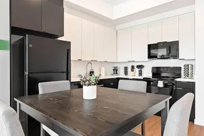 a kitchen with a wooden table and black appliances at Unique 1-Bedroom DTLA Escape with City Views in Los Angeles