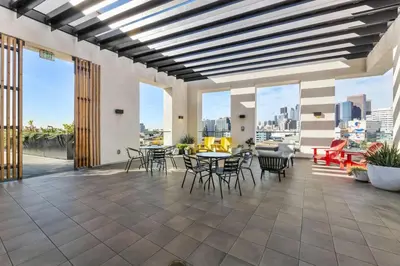 a large patio with tables and chairs and windows at Designer Stay in Arts District, Walk to Little Tokyo in Los Angeles