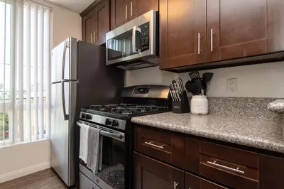 a kitchen with a stove and a microwave at Modern Hollywood Apt Rooftop Pool & Skyline Views in Los Angeles