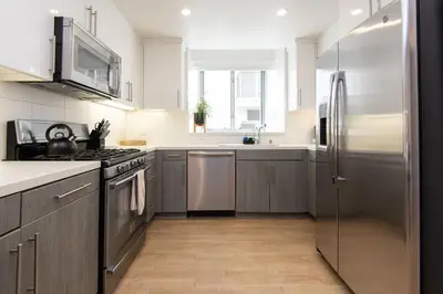 a kitchen with gray cabinets and stainless steel appliances at Walk to Santa Monica Beach Pier Boardwalk Venice in Los Angeles