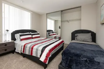 a bedroom with two beds and a mirror at Stylish 2BR Apt with Rooftop Pool & Hollywood Views in Los Angeles