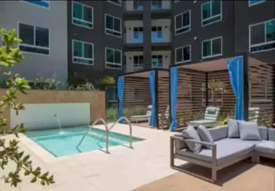 a patio with a couch and a pool in front of a building at Cozy 2bd Apt Near Disneyland Anaheim Conv Center in Anaheim