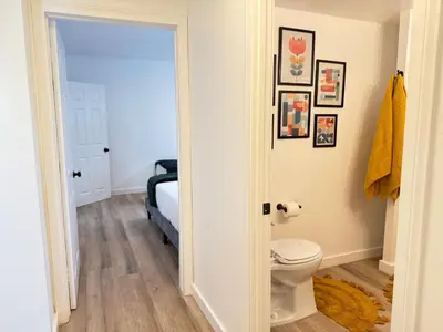 a bathroom with a toilet and pictures on the wall at Modern Duplex with 6 beds and Sofa bed in Miracle Mile Longwood in Los Angeles